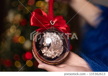 Christmas ornament horse figurine held by hand against festive bokeh background Christmas ornament horse figurine held by hand against festive bokeh background 135362613