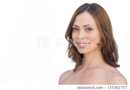 Woman smiling softly and posing with bare shoulders in studio white backdrop, copy space 135362757