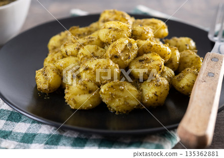 Gnocchi with pesto sauce served on black plate 135362881
