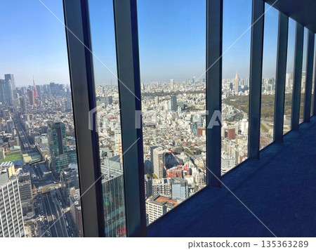 A spectacular view of Tokyo Tower and downtown Tokyo through the window frame. Blue skies and buildings from the observation deck. A spectacular view of Tokyo Tower and downtown Tokyo through the window frame. Blue skies and buildings from the observation deck. 135363289