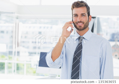 Adult man in shirt and tie calling via smartphone while standing at office desk, copy space 135363655