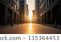 Modern urban street with golden sunset light between tall residential buildings creating dramatic shadows on empty pedestrian walkway 135364453