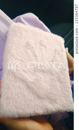 Close-up of a Pink Furry Notebook on a Car Seat in Natural Light Close-up of a Pink Furry Notebook on a Car Seat in Natural Light 135364797