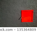 Bright Red Door Set Into Dark Textured Wall Creates Bold Industrial Contrast 135364809