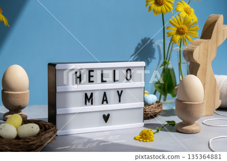 HELLO MAY text on Lightbox with bunny wooden figures eggs and fresh flowers. Easter composition content still life. Christian symbols of spring HELLO MAY text on Lightbox with bunny wooden figures eggs and fresh flowers. Easter composition content still life. Christian symbols of spring 135364881