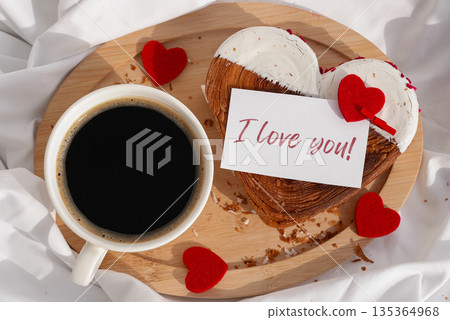 Flat lay top view I LOVE YOU saying on greeting card Morning breakfast in bed in wooden tray Present gift idea Valentine's Day Holiday celebration Heart shaped croissants. Puff pastry new trendy sweet Flat lay top view I LOVE YOU saying on greeting card Morning breakfast in bed in wooden tray Present gift idea Valentine's Day Holiday celebration Heart shaped croissants. Puff pastry new trendy sweet 135364968