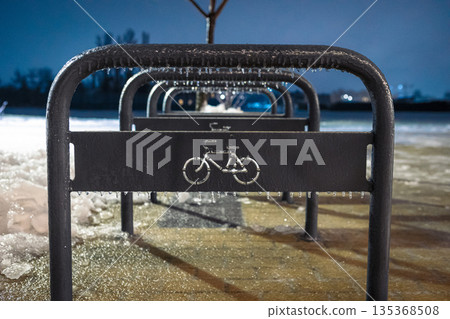 Sheffield type bicycle parking area in winter. Frozen metal structures on a snowy evening. Sheffield type bicycle parking area in winter. Frozen metal structures on a snowy evening. 135368508