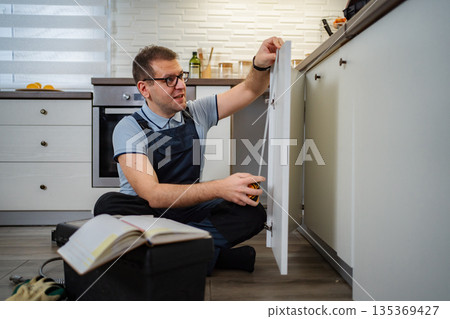 Man measuring kitchen cabinet for home renovation DIY project 135369427