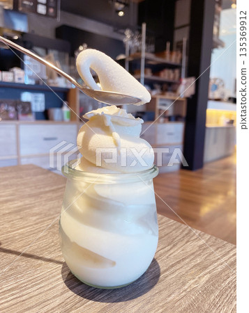 牛奶軟冰淇淋:盛裝在玻璃杯中的濃鬱牛奶冰淇淋。 牛奶軟冰淇淋:盛裝在玻璃杯中的濃鬱牛奶冰淇淋。 135369912