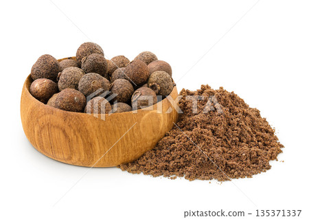 Allspice pepper and ground in wooden bowl isolated on white background. Jamaica pepper, Pimenta dioica or myrtle pepper Allspice pepper and ground in wooden bowl isolated on white background. Jamaica pepper, Pimenta dioica or myrtle pepper 135371337