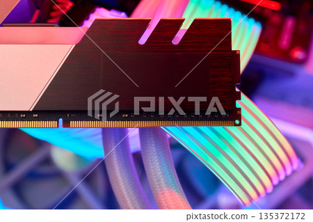 Elegant gaming hardware, High-performance RAM with cooling system, Premium illuminated memory module for gaming PCs, Sleek neon lit RAM with cooling and metallic heat sink design Elegant gaming hardware, High-performance RAM with cooling system, Premium illuminated memory module for gaming PCs, Sleek neon lit RAM with cooling and metallic heat sink design 135372172