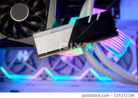 Elegant gaming hardware, High-performance RAM with cooling system, Premium illuminated memory module for gaming PCs, Sleek neon lit RAM with cooling and metallic heat sink design Elegant gaming hardware, High-performance RAM with cooling system, Premium illuminated memory module for gaming PCs, Sleek neon lit RAM with cooling and metallic heat sink design 135372186