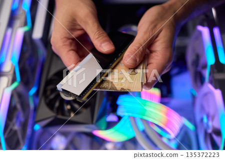 Hidden cash stored in computer memory modules, Covert operation involving cash hideaway inside memory hardware amid colorful RGB illumination and mining equipment 135372223