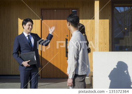 一位銷售員正在帶領參觀房屋展覽會。 135372364
