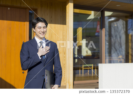 一位銷售員正在帶領參觀房屋展覽會。 135372370