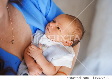 Newborn baby held by parent in soft clothing at home Newborn baby held by parent in soft clothing at home 135372509
