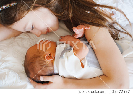 Sibling moment between young girl and newborn baby Sibling moment between young girl and newborn baby 135372557