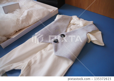 Baby outfit on a blue surface with a white background Baby outfit on a blue surface with a white background 135372615