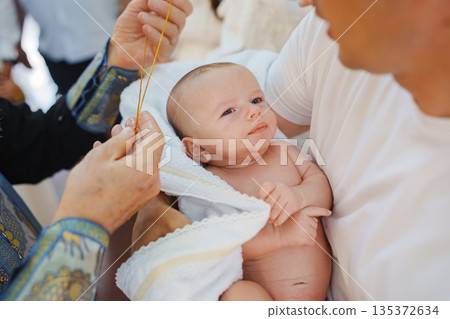 Newborn blessing ceremony in a sunny outdoor setting Newborn blessing ceremony in a sunny outdoor setting 135372634