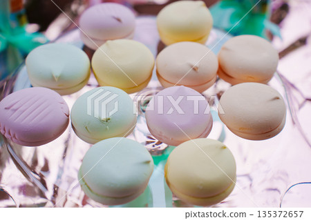 Colorful macaroons on a clear dish at a dessert table 135372657
