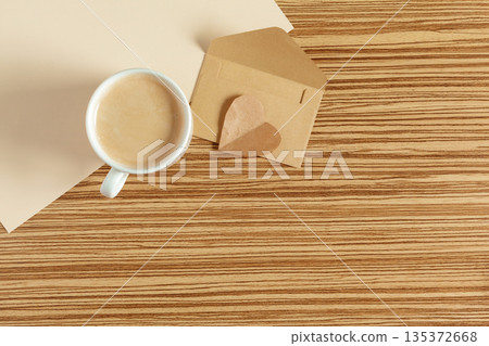Coffee sits on a wooden table next to a small beige box at a cafe in the afternoon 135372668