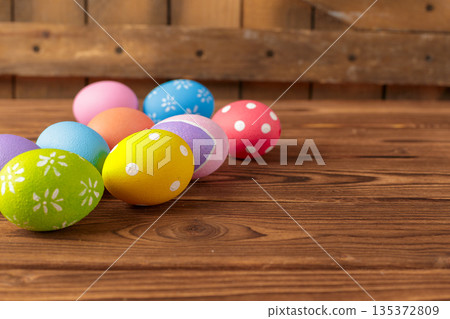 Colorful eggs are arranged on a wooden table for a festive celebration in spring Colorful eggs are arranged on a wooden table for a festive celebration in spring 135372809
