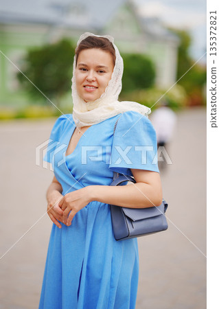 Woman in blue dress with scarf enjoying a sunny day 135372821