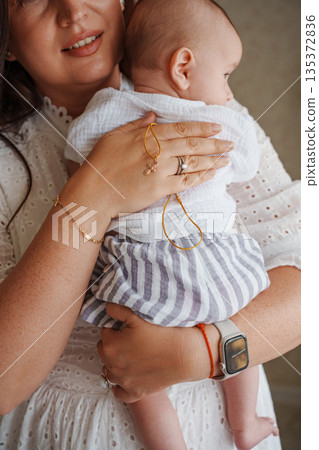 Baby held lovingly by parent against smooth background Baby held lovingly by parent against smooth background 135372836