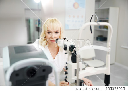 Ophthalmologist examines patient in eye clinic 135372925