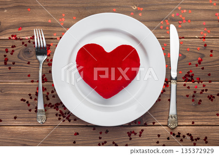 Heart shape decoration on a plate with utensils for a special meal event 135372929