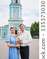 Family poses together in front of blue church 135373030