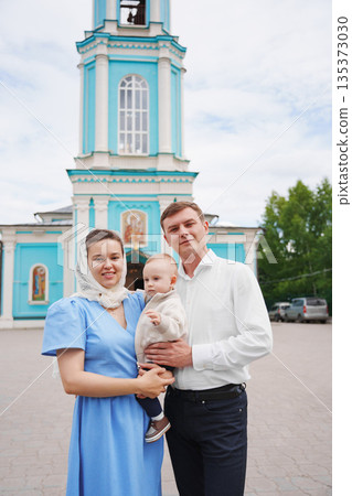 Family poses together in front of blue church 135373030