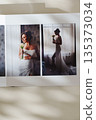 page of an open photo book with wedding photos on a white table 135373034