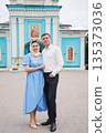Couple posing in front of colorful church during daytime 135373036