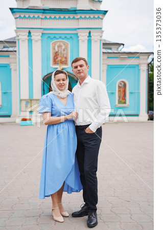 Couple posing in front of colorful church during daytime Couple posing in front of colorful church during daytime 135373036