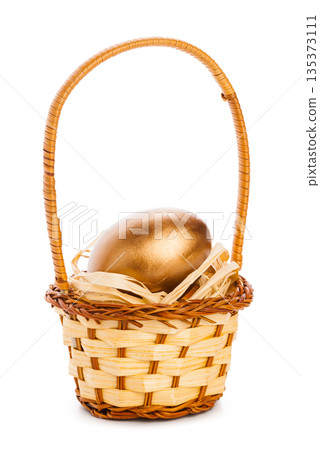Golden egg placed in a woven basket filled with straw Golden egg placed in a woven basket filled with straw 135373111