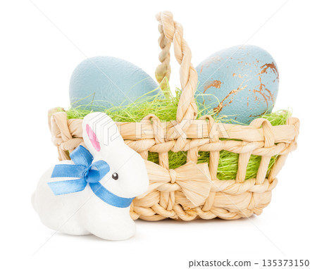 Easter basket with blue eggs and a white bunny on a simple background Easter basket with blue eggs and a white bunny on a simple background 135373150