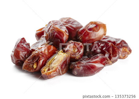 Dried dates are arranged on a white surface in a food display Dried dates are arranged on a white surface in a food display 135373256