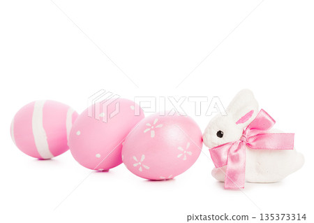 Pink Easter eggs and bunny with ribbon sitting on a white background 135373314