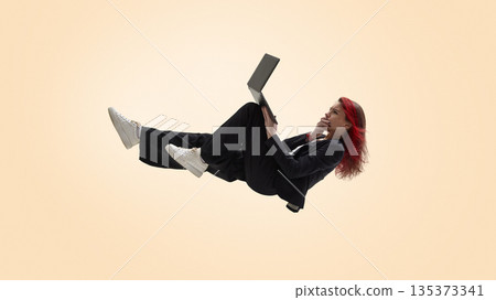 Freelancer working remotely on laptop in relaxed floating position. 135373341