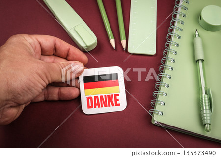 Thanks in German Message With German Flag Held Beside Green Stationery Items Thanks in German Message With German Flag Held Beside Green Stationery Items 135373490