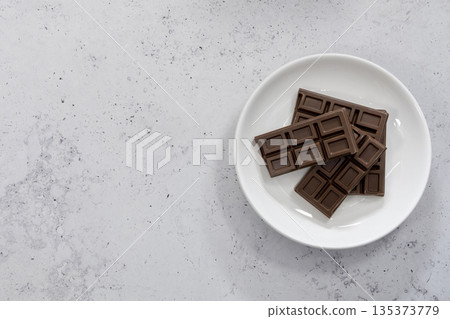 Chocolate bar on a white plate Chocolate bar on a white plate 135373779