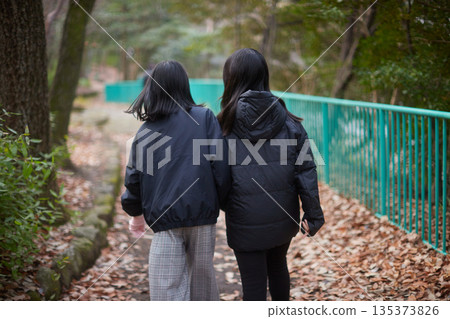 冬日清晨，一對國中姊妹沿著林間小路漫步。 135373826