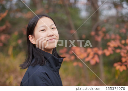 A cute junior high school girl walking in the winter forest and autumn leaves A cute junior high school girl walking in the winter forest and autumn leaves 135374078