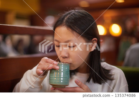 冬天，一位可愛的國中女生在咖啡館喝茶。 135374086