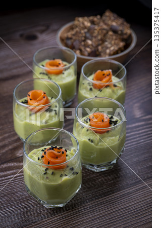 Smoked salmon shot glasses guacamole served with homemade crackers 135375417