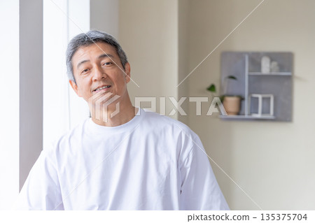 Senior men standing at the windowside Senior men standing at the windowside 135375704