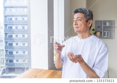 一位老人在窗邊吃藥 135375813