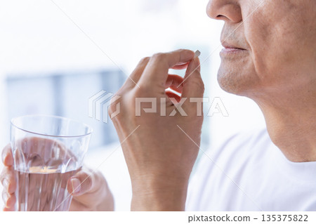 一位老人在窗邊吃藥 135375822