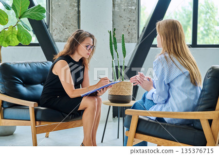 Mental therapy session, female professional psychologist working with young woman patient Mental therapy session, female professional psychologist working with young woman patient 135376715